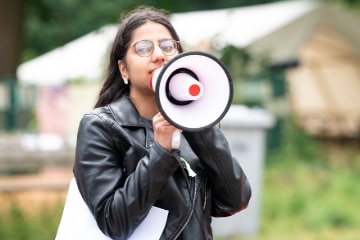 Mädchen in schwarzer Lederjacke mit Megafon