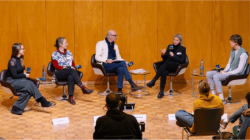 Eine Gruppe von fünf Menschen diskutiert auf einer Bühne